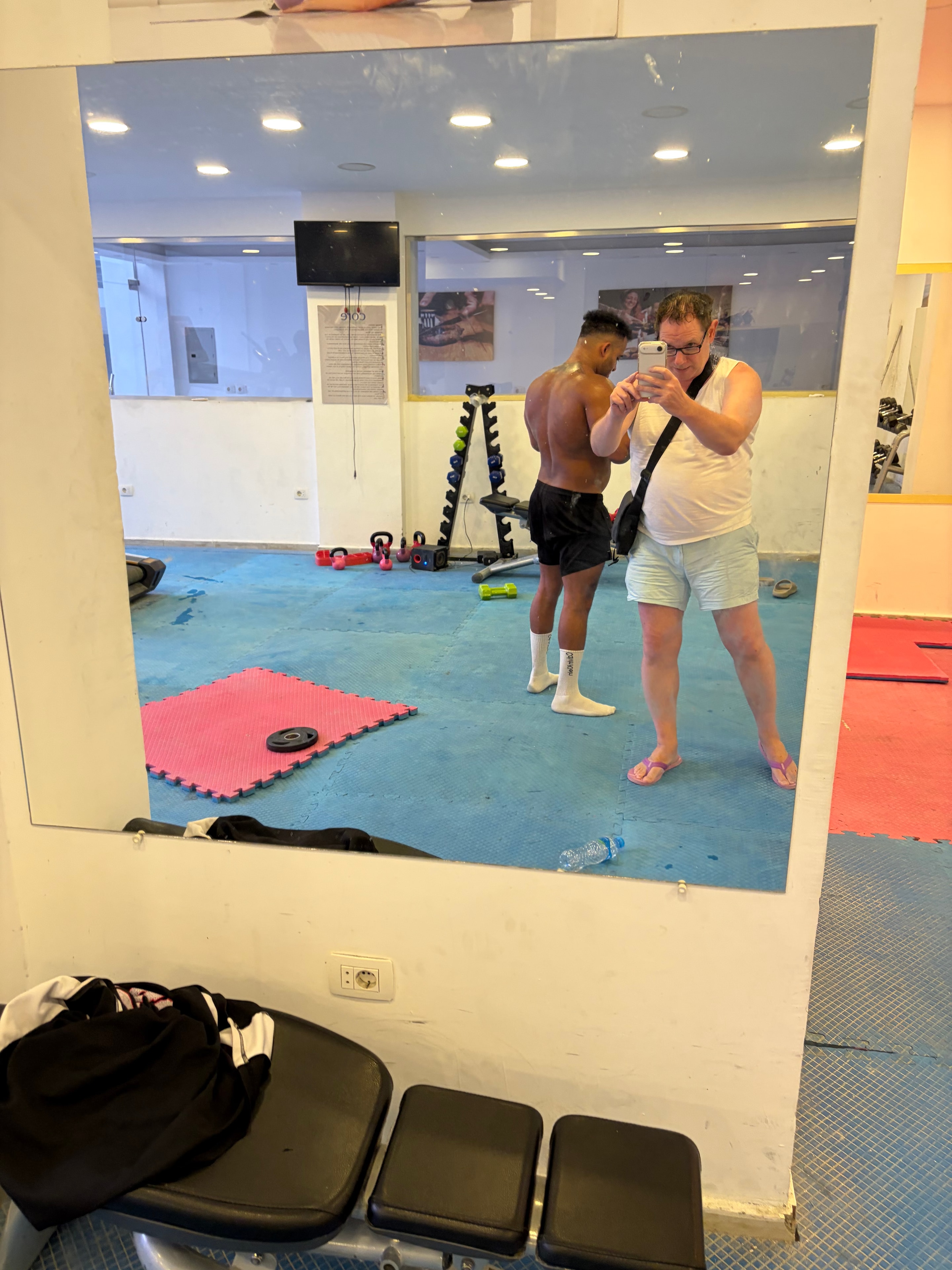 Scratched scuffed walls with single weight plate and flip-flops on floor