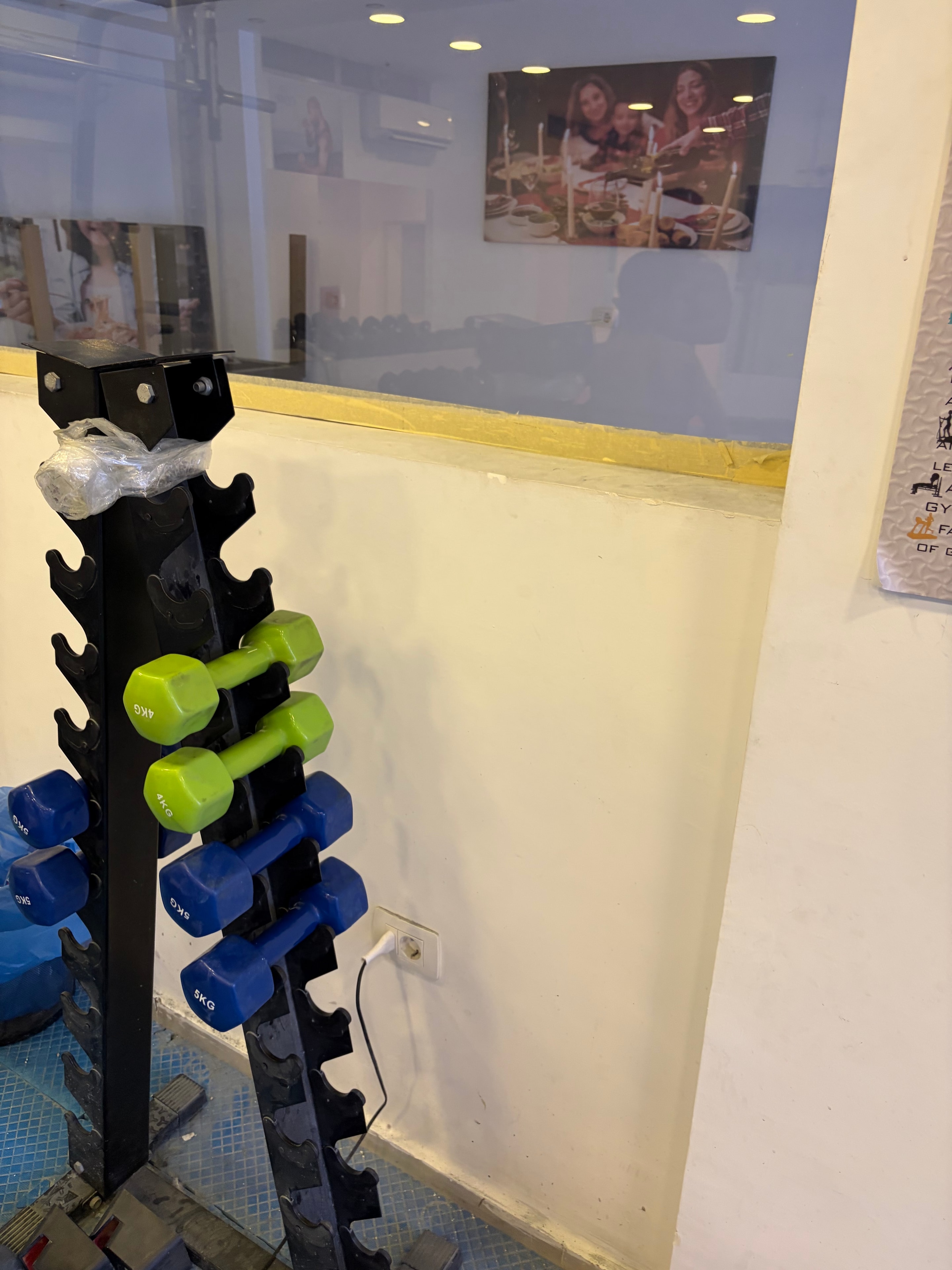 Empty exercise room with bare white walls, stacked foam mats and two gym balls