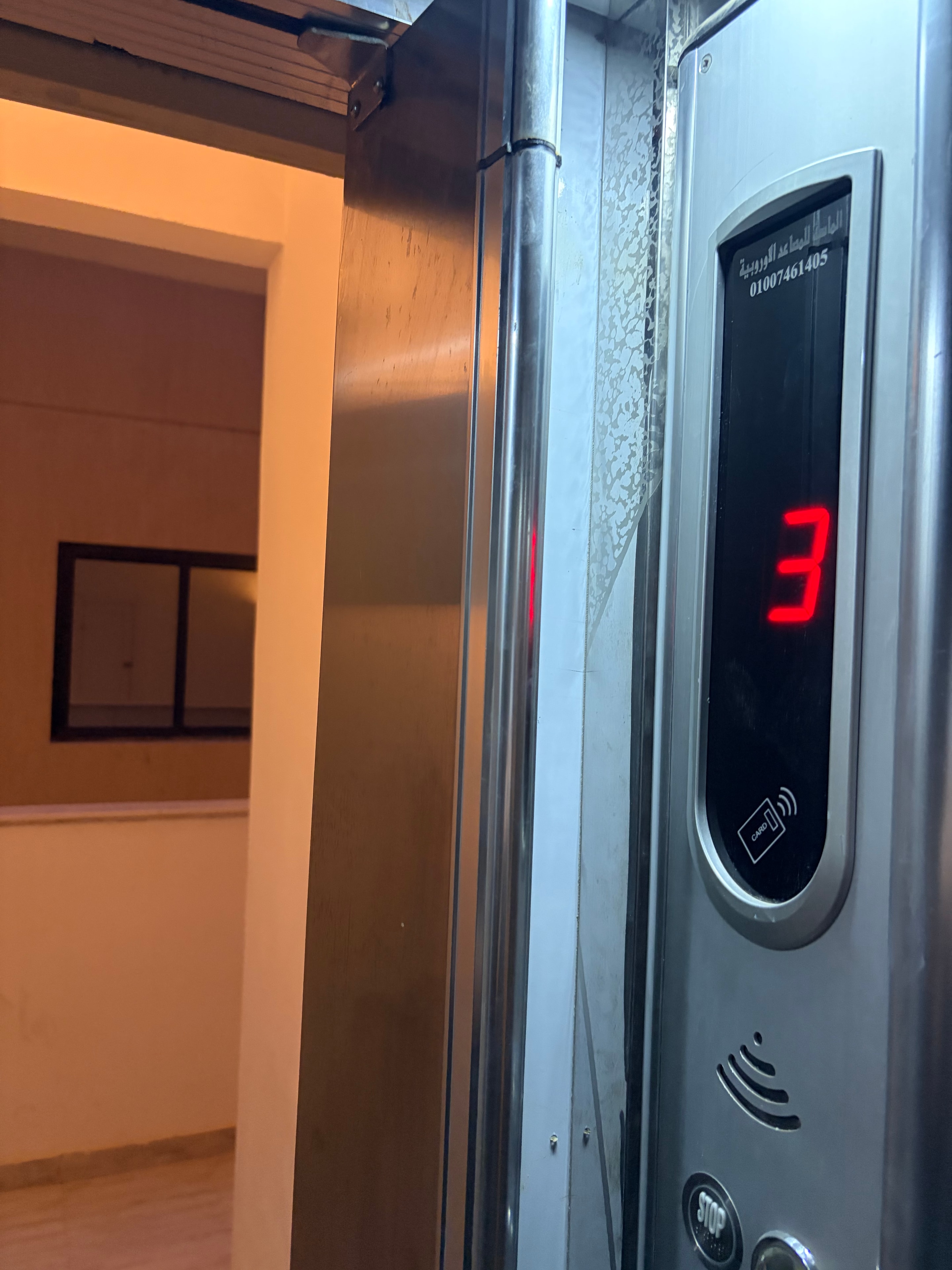 Lift shaft fully exposed through gap where safety door should be — entire shaft interior visible