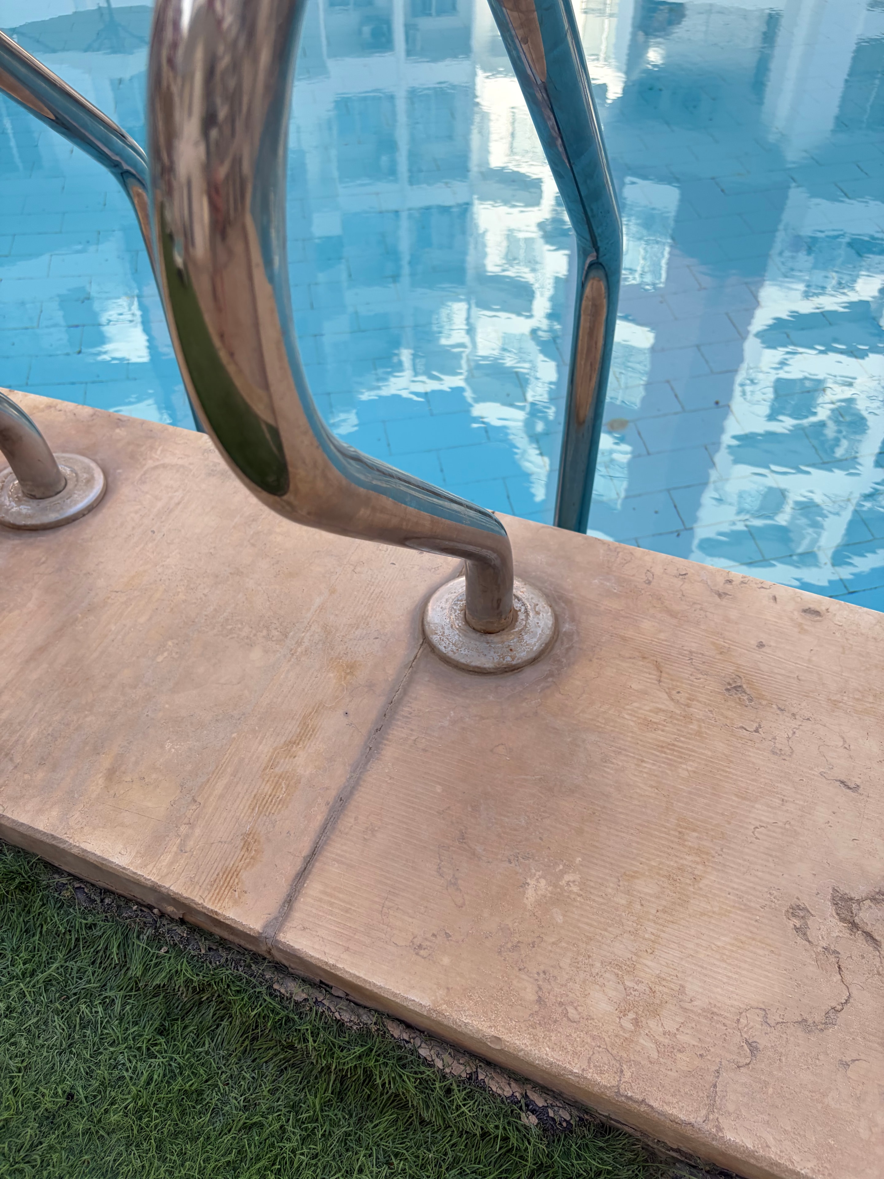 Mismatched floor tiles with faecal handprint pressed onto dark replacement tiles — botched repair work clearly visible