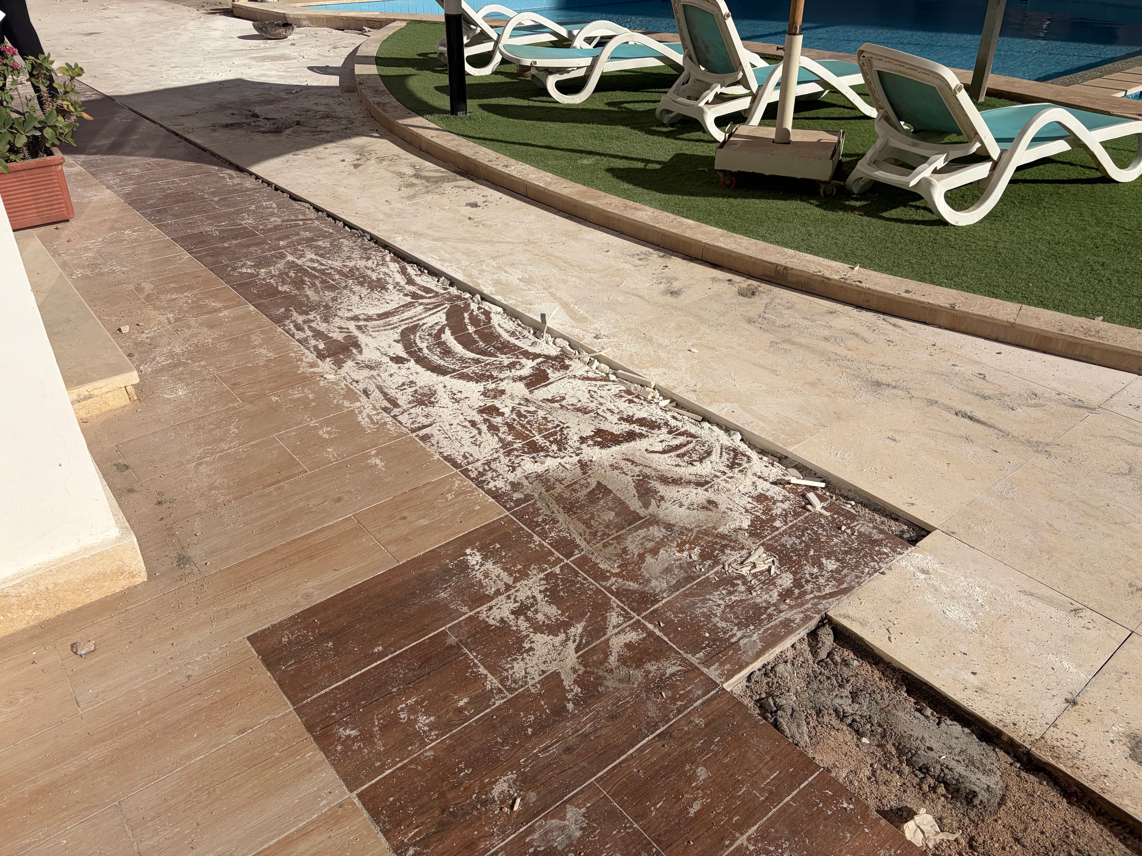 Pool area — mismatched tile repair second angle — botched repair work with non-matching tiles clearly visible