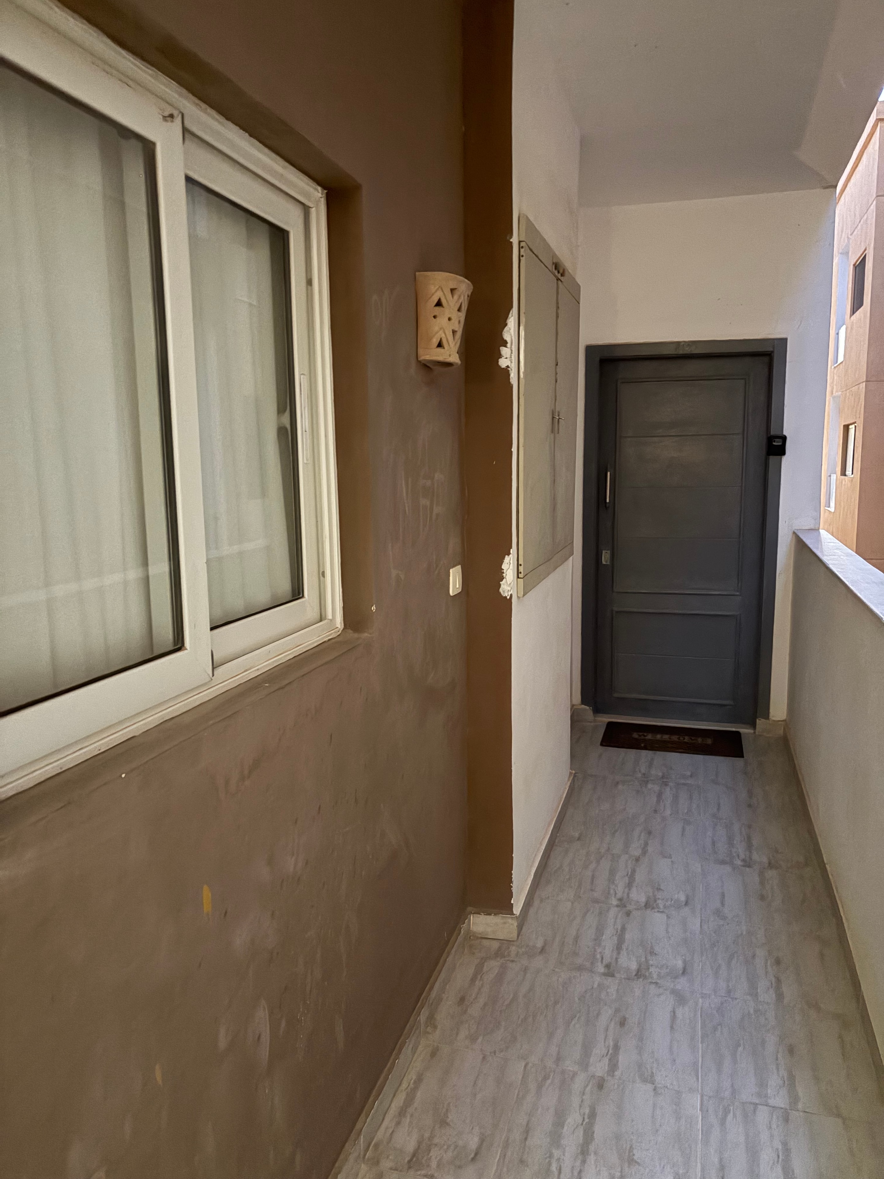 Staircase wide shot — marble-effect tiles heavily stained and marked with paint splashes across multiple steps, bottom newel post cladding crumbling away